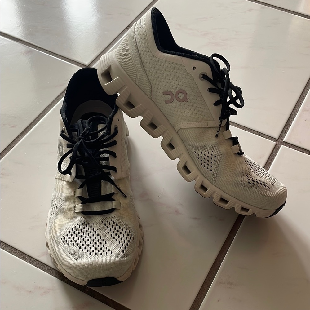 On Running Cream and Black Sneakers